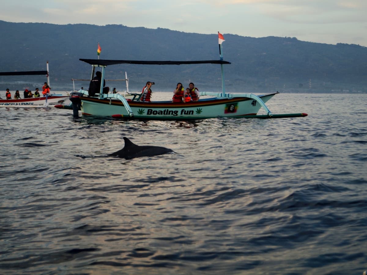 Bali Lovina — fishing boats on a calm north-coast black-sand beach at sunrise