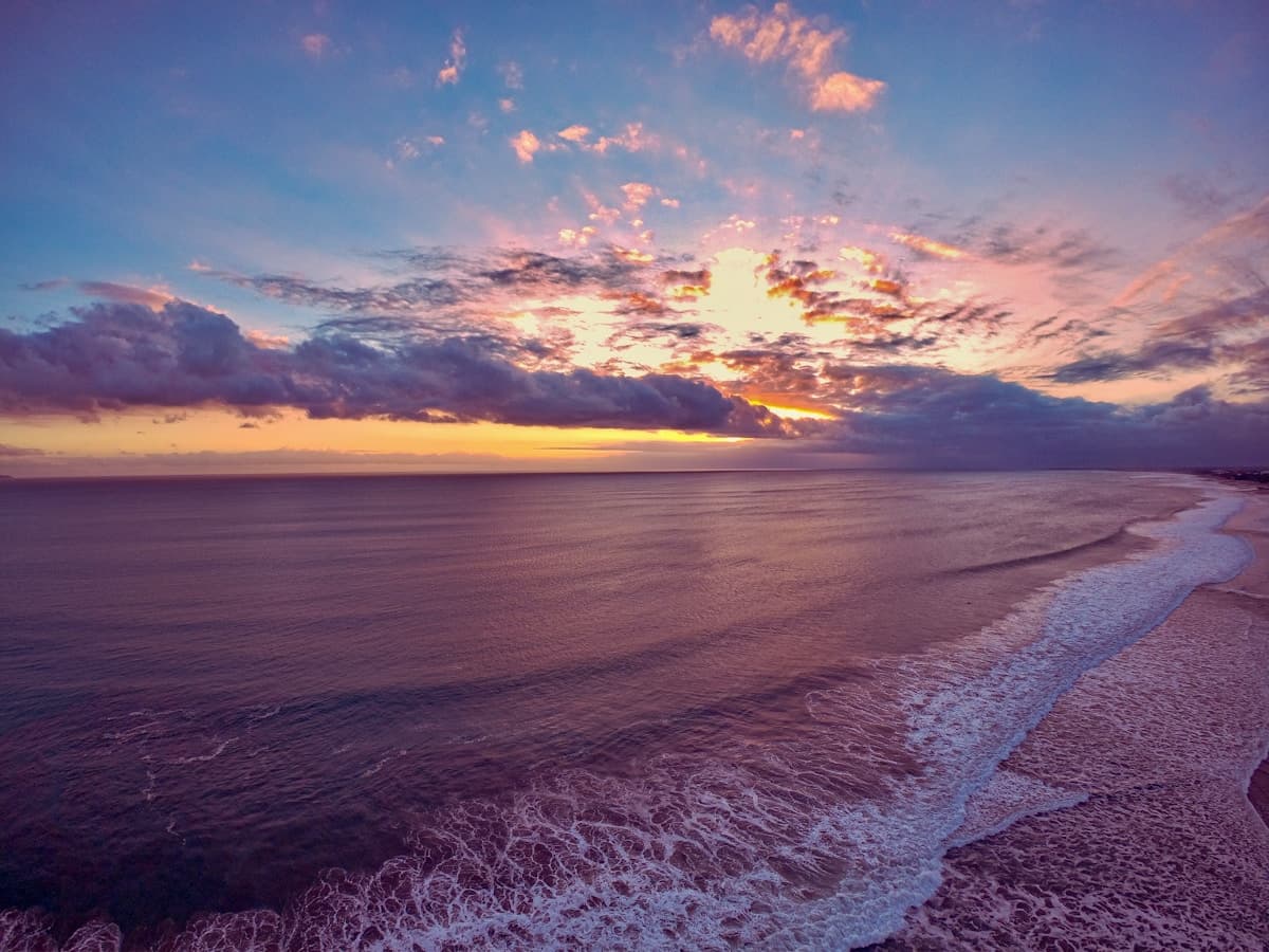 Bali Seminyak — beach club loungers facing the Indian Ocean at sunset