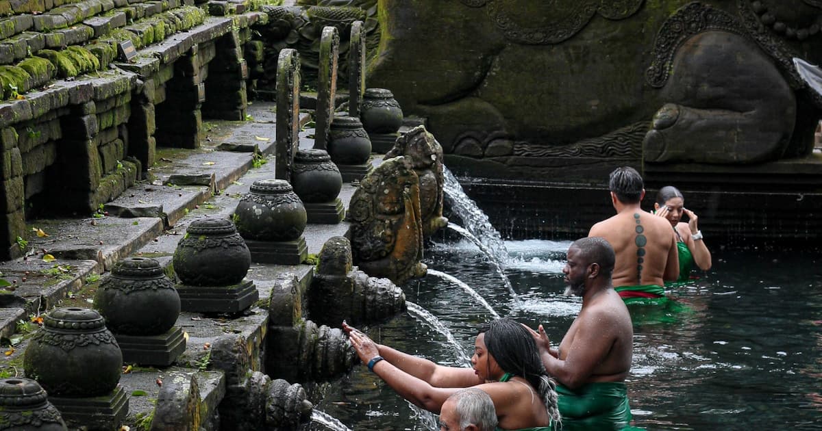Bali โ pilgrims bathing in the sacred spring pools of Tirta Empul temple